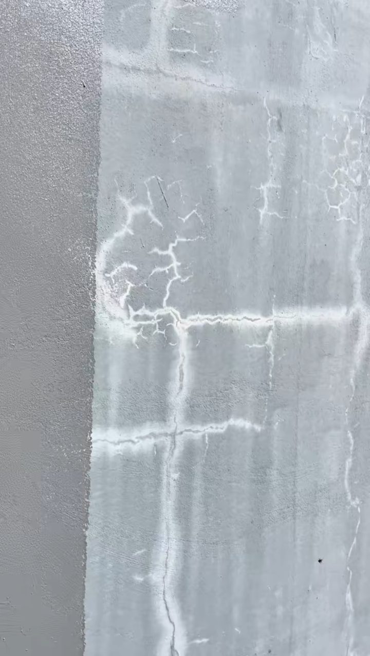 Mur à moitié traité : partie gauche recouverte de Polylastic, partie droite pleine de fissures